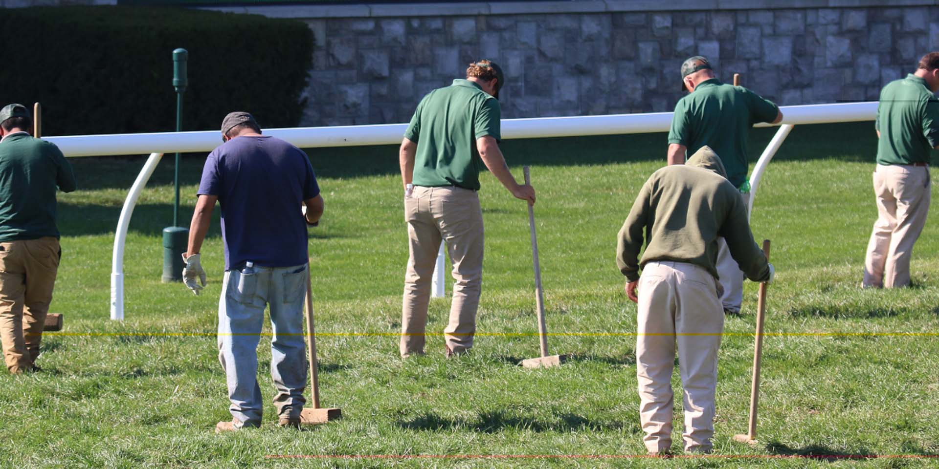 An action shot of Swiftjockey team members tamping down turf divots.